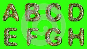 Alphabet from plastic with abstract holes isolated on a green background. A B C D E F G H . 4K