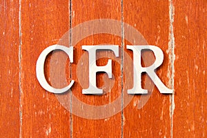 Alphabet in word CFR abbreviation Cost and freight on old red color wood plate background