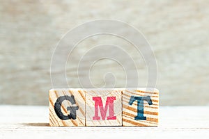 Alphabet in word GMT abbreviation of Greenwich Mean Time on wood background