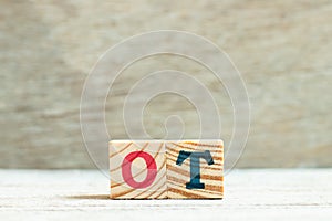 Alphabet in word ot abbreviation for overtime on wood background