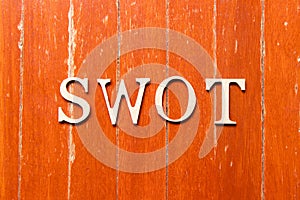 Alphabet in word swot abbreviation of strength, weakness, opportunities, threats on old red color wood plate background