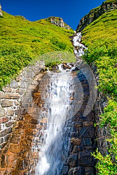 Alpin waterfalls under a blue sky, summer season photo