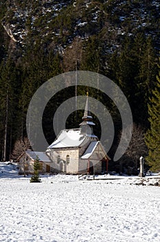 Alpine church near Braies lake along the walkway between the forest