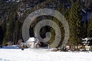 Alpine church near Braies lake along the walkway between the forest