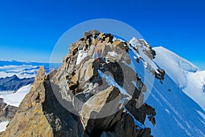 Alpine climber on rock and snow mountain ridge