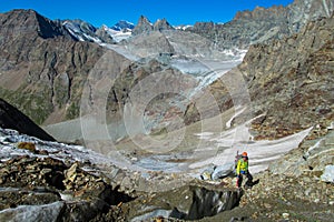 Alpine climber on rock and snow mountain ridge