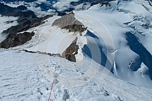 Alpine climber on snow mountain ridge