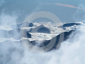 Alpine cloudscape nature panorama mountain peaks peeking through clouds seen from Brewster Hut Southern Alps New Zealand photo