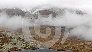 Alpine lake in the clouds. Alpine lake with rocky shores and emerald water in the clouds. Alpine lake Giybashkel