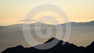 Alpine landscape with mountain ranges silhouettes during foggy sunset, Europe, Slovakia