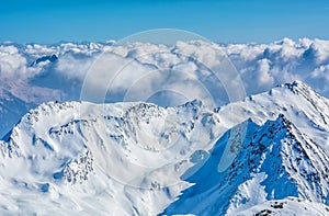 Alpine landscape with peaks covered by snow and clouds