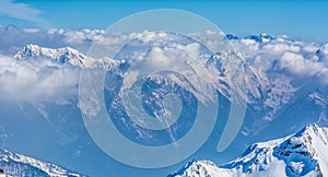 Alpine landscape with peaks covered by snow and clouds