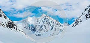 Alpine landscape with peaks covered by snow and clouds