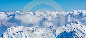 Alpine landscape with peaks covered by snow and clouds