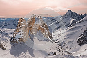 Alpine landscape with peaks covered by snow and clouds, beautiful colors at the top of a glacier.