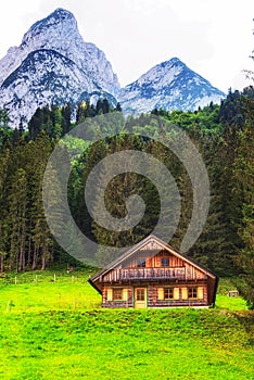 Alpine meadow with some cottages and the Gosau mountain peaks in the background