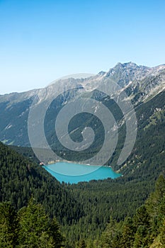 Alpine mountain lake Lago di Anterselva in the middle of pine forest in the Italian Dolomites photo