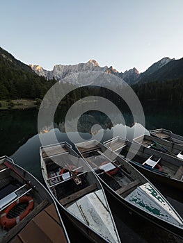Alpine mountain lake rowing boat landscape panorama at Laghi di Fusine Weissenfelser See Tarvisio Dolomites alps Italy