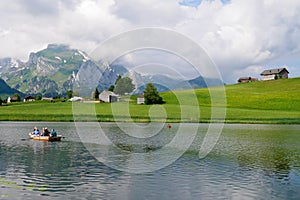 Alpine mountain lake Schwendisee in Toggenburg. Saentis range in the background. St. Gallen, Switzerland.