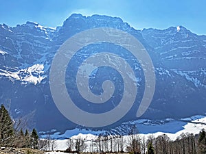 The alpine mountain range GlÃ¤rnisch in the Swiss massif of Glarus alps and over the KlÃ¶ntalersee reservoir lake