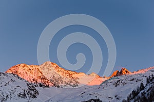 Alpine mountain ridges illuminated in golden hour in winter