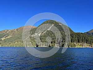 Alpine mountain Seehorn (2238 m) covered with evergreen forest above the tourist and sports mountain lake Davos