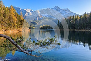 Alpine panorama of Lake Eibsee with Germanys highest mountain Zugspitze in the background on a sunny afternoon in autumn