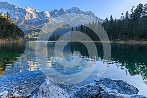 Alpine panorama of Lake Eibsee with Germanys highest mountain Zugspitze in the background on a sunny afternoon in autumn