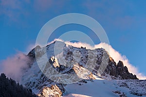 Alpine peak in winter with storm clouds building behind