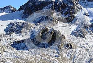 Alpine rock Isla Persa next to the autumn remains of the Vardet da Grialetsch glacier and in the Albula Alps mountain massif photo