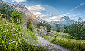 Alpine scenery in the Dolomites with mountain chalets at sunset in summer