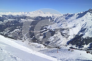 Alpine ski resort valley against snowy mountain range