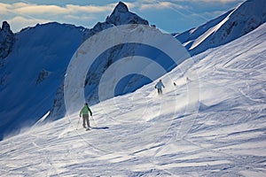 Alpine skiers embrace the stunning snowy backdrop of the mountain range