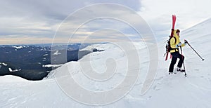 Alpine touring skier hiking in winter mountains.