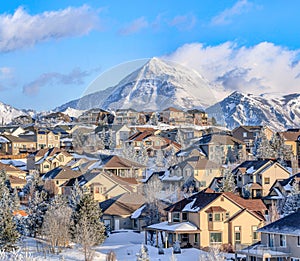 Alpine Utah in winter with houses against snowy mountain and cloudy blue sky photo