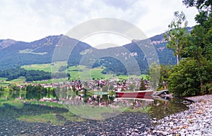 Alpine village in Switzerland reflecting in a lake.