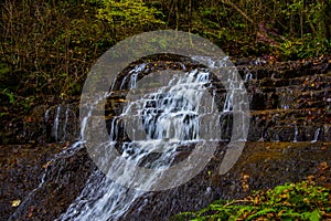 Alpine waterfall in the autumn woods