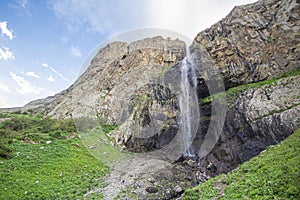Alpine waterfall in the mountains of kyrgyzstan flowing from melting glaciers close-up