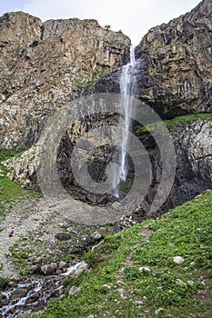 Alpine waterfall in the mountains of kyrgyzstan flowing from melting glaciers close-up