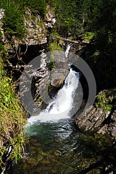 Alpine waterfall Riesachwasserfall from lake Riesachsee near Schladming in Austria