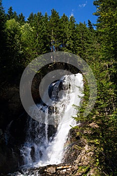 Alpine waterfall Riesachwasserfall from lake Riesachsee near Schladming in Austria