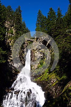 Alpine waterfall Riesachwasserfall from lake Riesachsee near Schladming in Austria