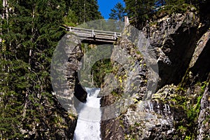 Alpine waterfall Riesachwasserfall from lake Riesachsee near Schladming in Austria