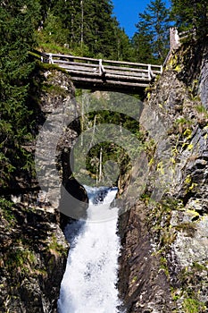 Alpine waterfall Riesachwasserfall from lake Riesachsee near Schladming in Austria