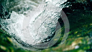 Alpine whitewater waterfall and green moss, slow motion shot