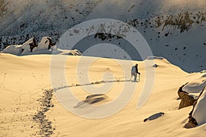 Alpinist alone exploring mountains at magical sunset in Swiss Alps, Switzerland