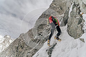 An alpinist climbing in winter alpine like landscape of High Tatras