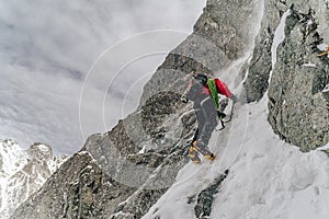 An alpinist climbing in winter alpine like landscape of High Tatras