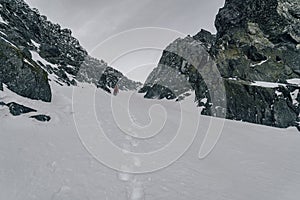 An alpinist climbing in winter alpine like landscape of High Tatras