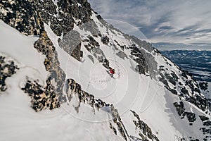 Horolezec lezící v zimní alpské krajině Vysokých Tater